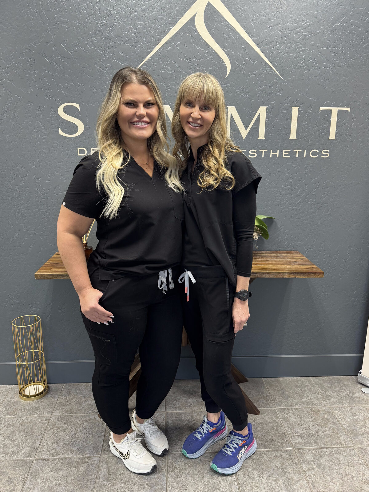 Summit team members in front of the Summit logo wall